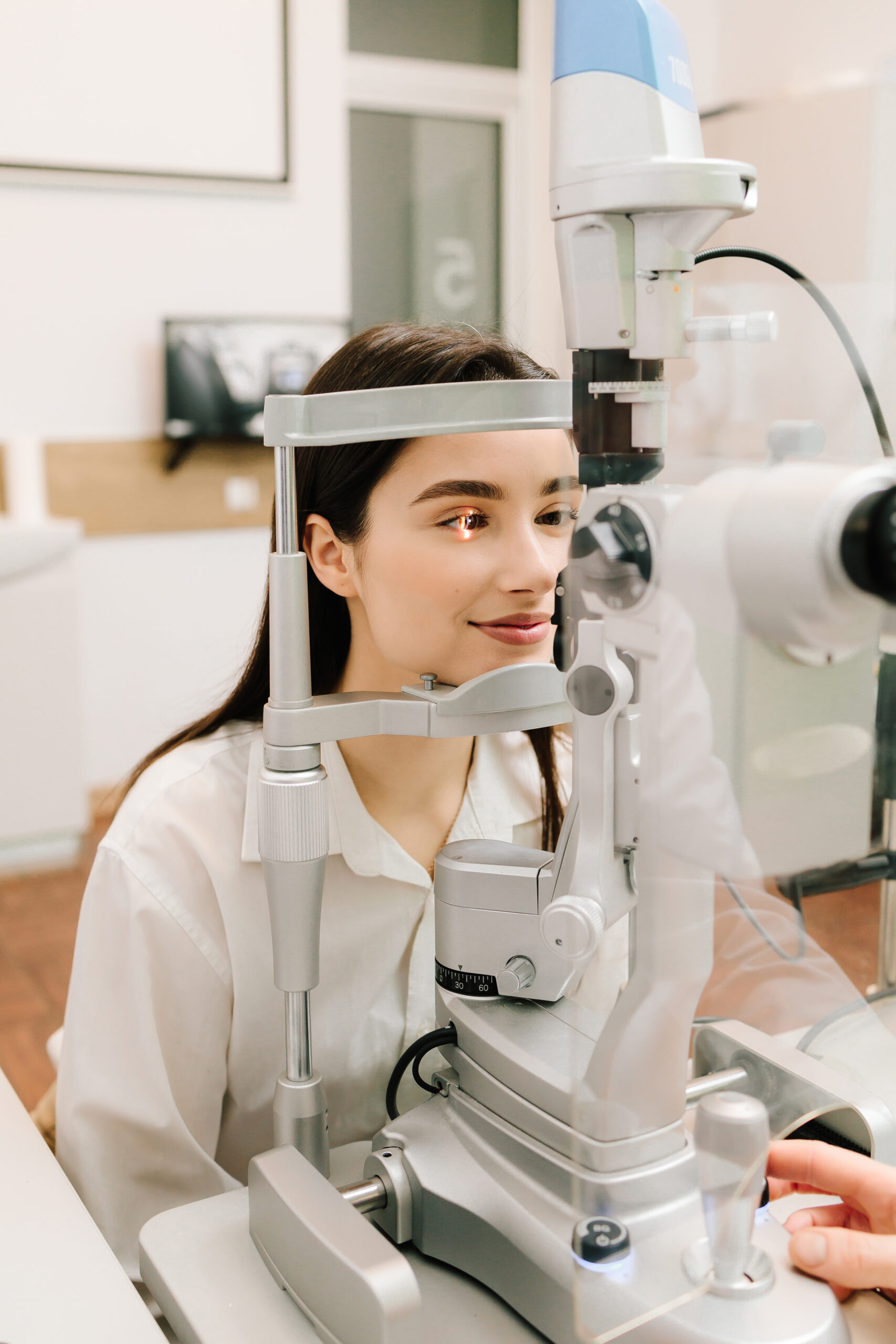 Slit lamp eye and cornea diagnostic at visiting ophthalmology clinic. Light on eye from slit lamp for examination eyes and cornea of girl
